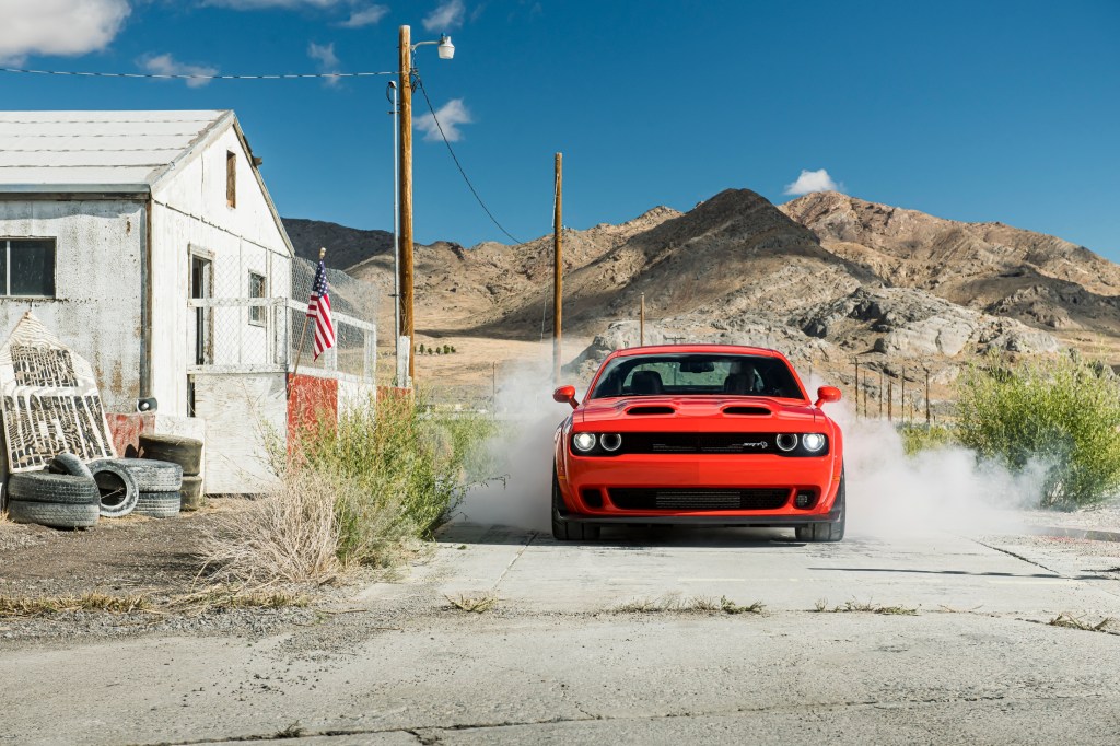 Red 2020 Dodge Challenger SRT Super Stock doing a burnout in an old desert town