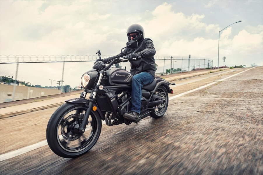 A gray-purple 2020 Kawasaki Vulcan S rides down a wet city street