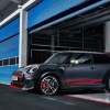 A black-and-red 2020 Mini Cooper JCW GP coming out of a blue track-side garage
