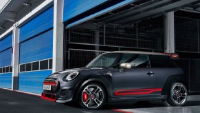 A black-and-red 2020 Mini Cooper JCW GP coming out of a blue track-side garage