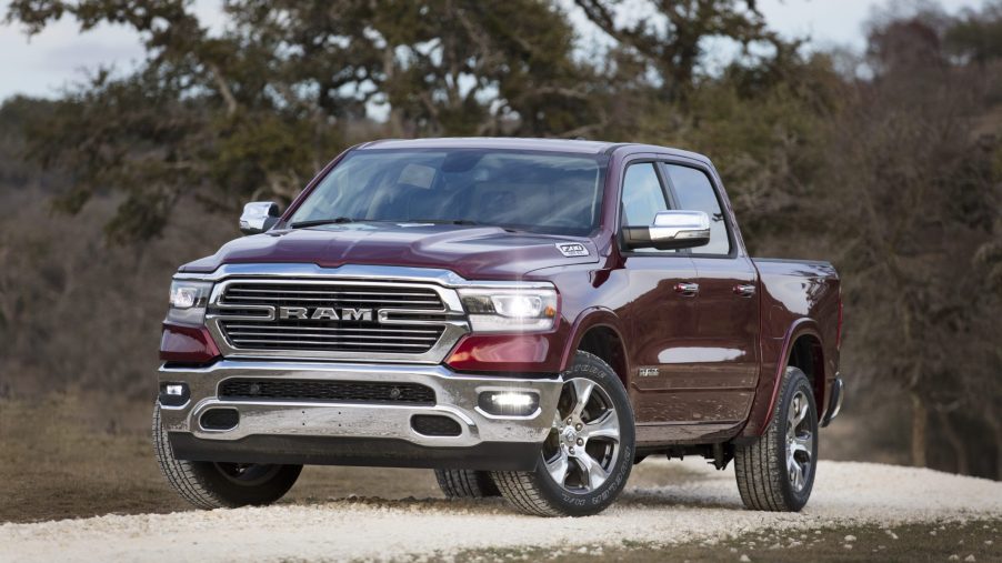 A burgundy Ram 1500 Laramie sits in the curve or a dirt road.
