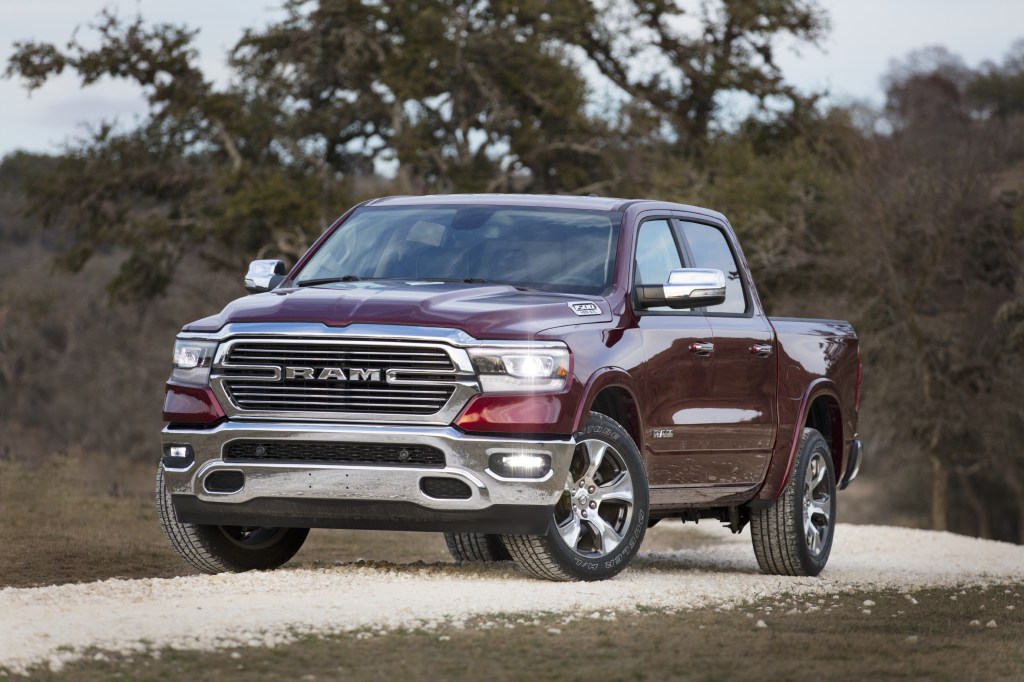 A burgundy Ram 1500 Laramie sits in the curve or a dirt road. 