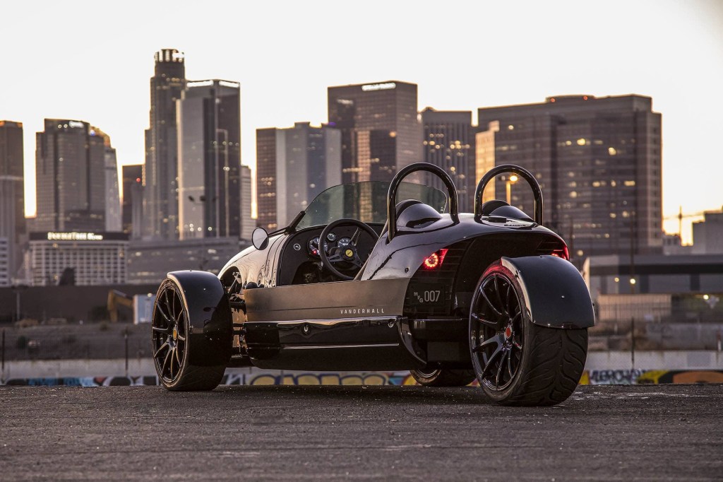 Rear view of the electric 3-wheeled 2020 Vanderhall Edison 2 in front of a cityscape