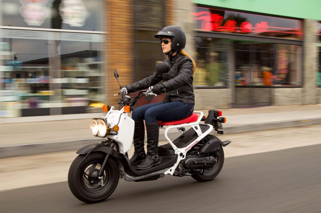 Riding a white 2020 Honda Ruckus in the city