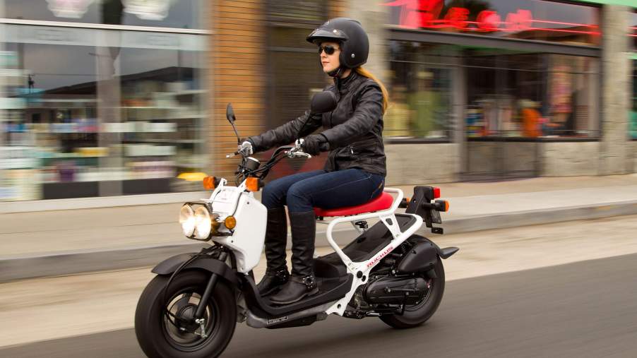 Riding a white 2020 Honda Ruckus in the city