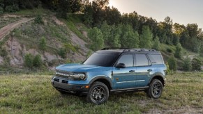 blue 4-door 2021 Ford Bronco Sport parked in grass on off-roading trail