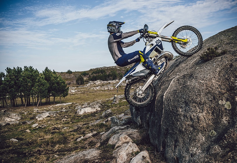The 2021 Husqvarna 2-stroke TE 250i enduro bike riding up a large boulder