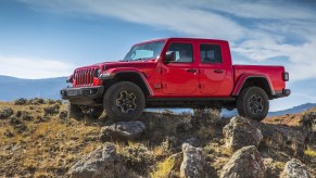 A red 2021 Jeep Gladiator sits atop of rocks.