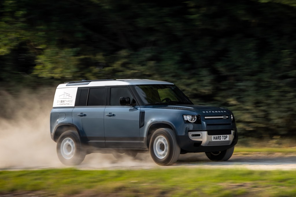Blue 2021 Land Rover Defender Hard Top 110 panel van driving down a country road