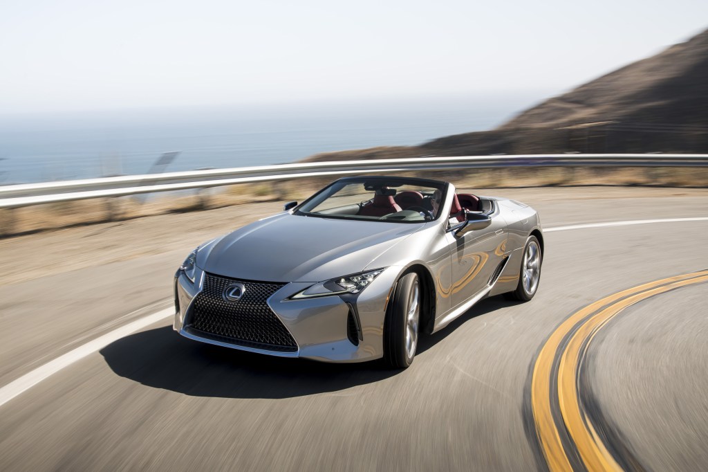 A silver, topless 2021 Lexus LC 500 Convertible rounds a turn on a coaster road.