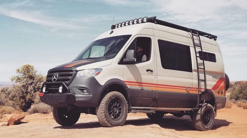 A white-with-orange-and-yellow-striped 2021 Mercedes Sprinter Beast Mode 4x4 in the desert