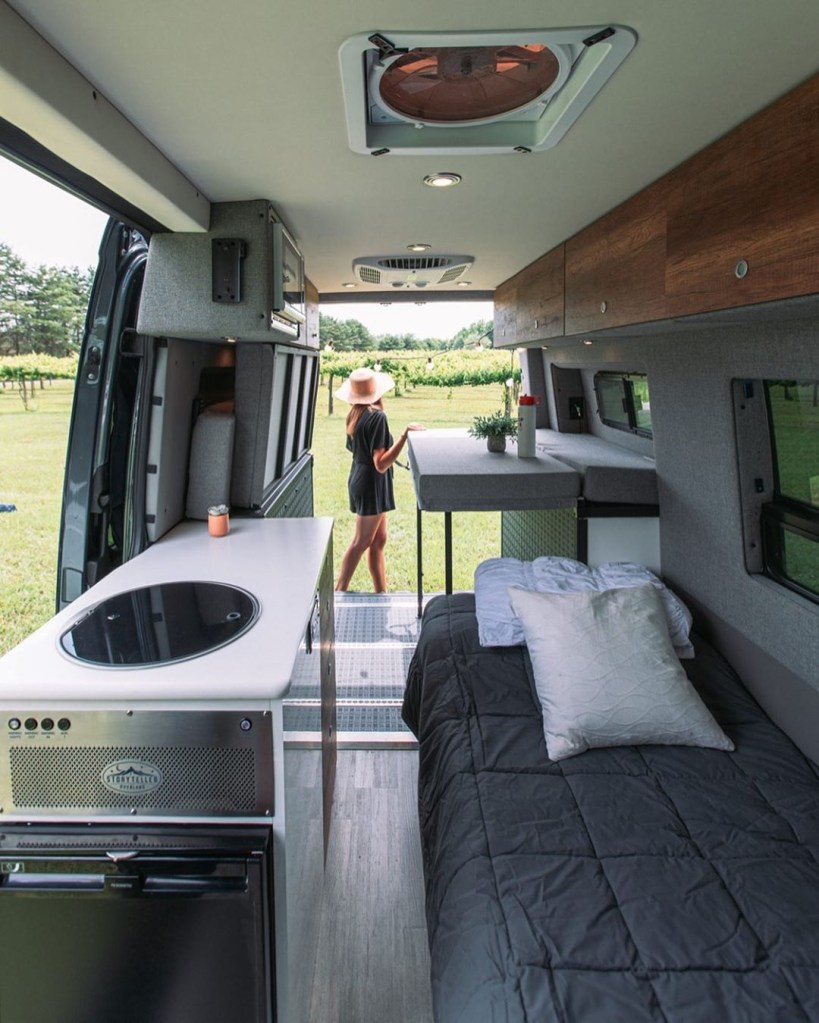 Interior shot of the 2021 Mercedes Sprinter Stealth Mode 4x4, showing the convertible sofa-bed and kitchen area