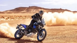 A blue-tanked 2021 Yamaha Ténéré 700 adventure bike power-sliding in the desert