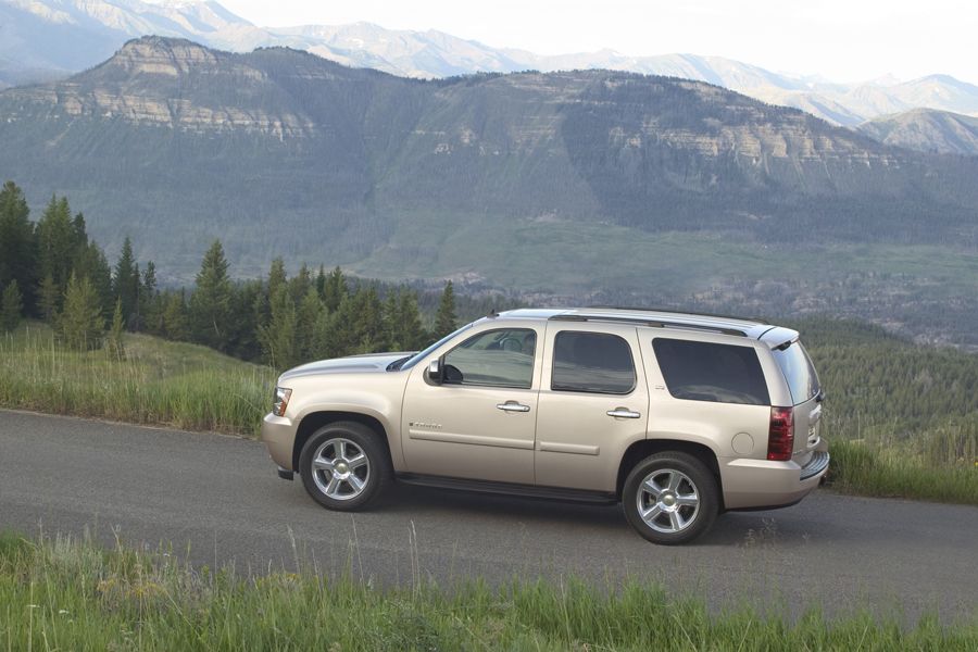 A gold 2010 Chevy Tahoe climbing a scenic mountain road