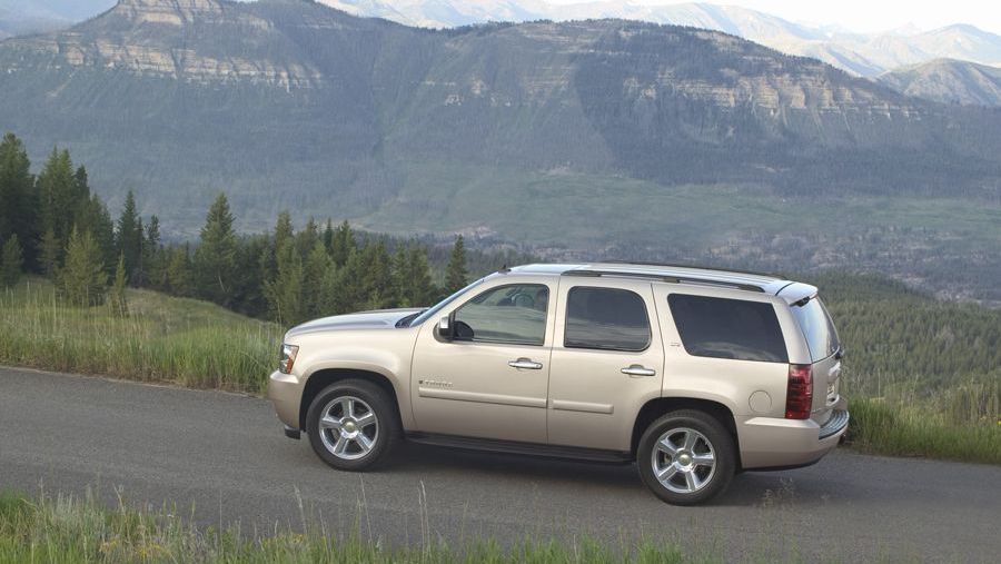 A gold 2010 Chevy Tahoe climbing a scenic mountain road