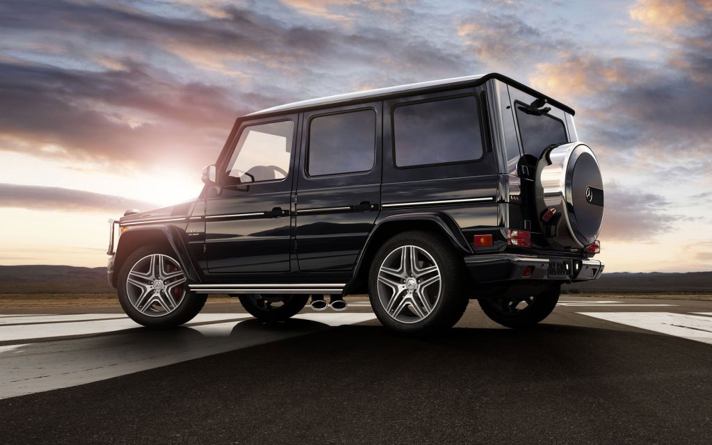 A black 2014 G-Class  SUV parked near the countryside.