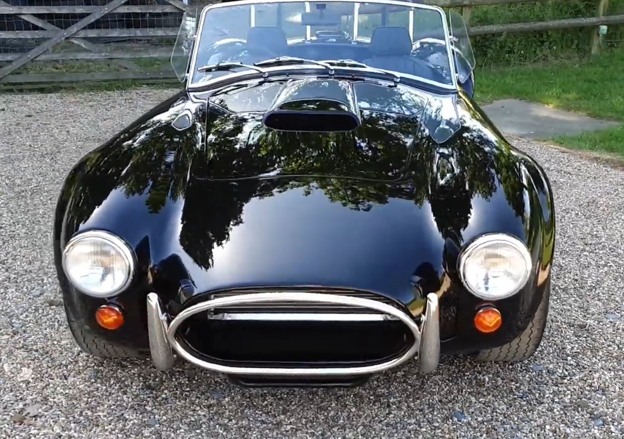 A head-on picture of a black Cobra convertible