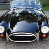 A head-on picture of a black Cobra convertible