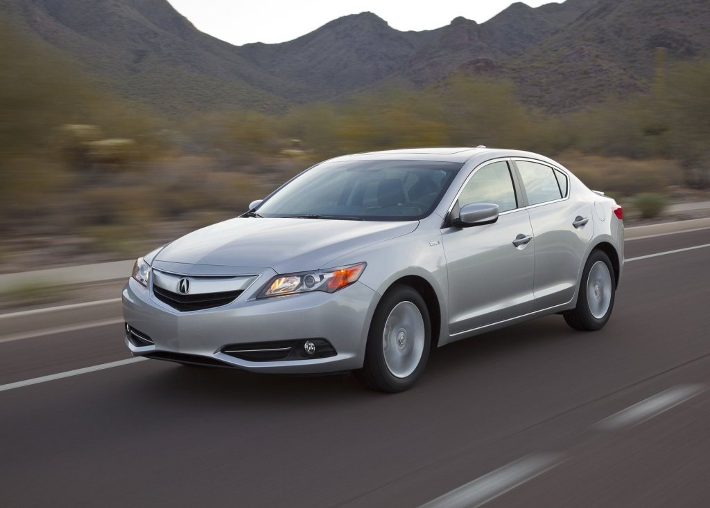 A silver 2013 Acura ILX drives down the road