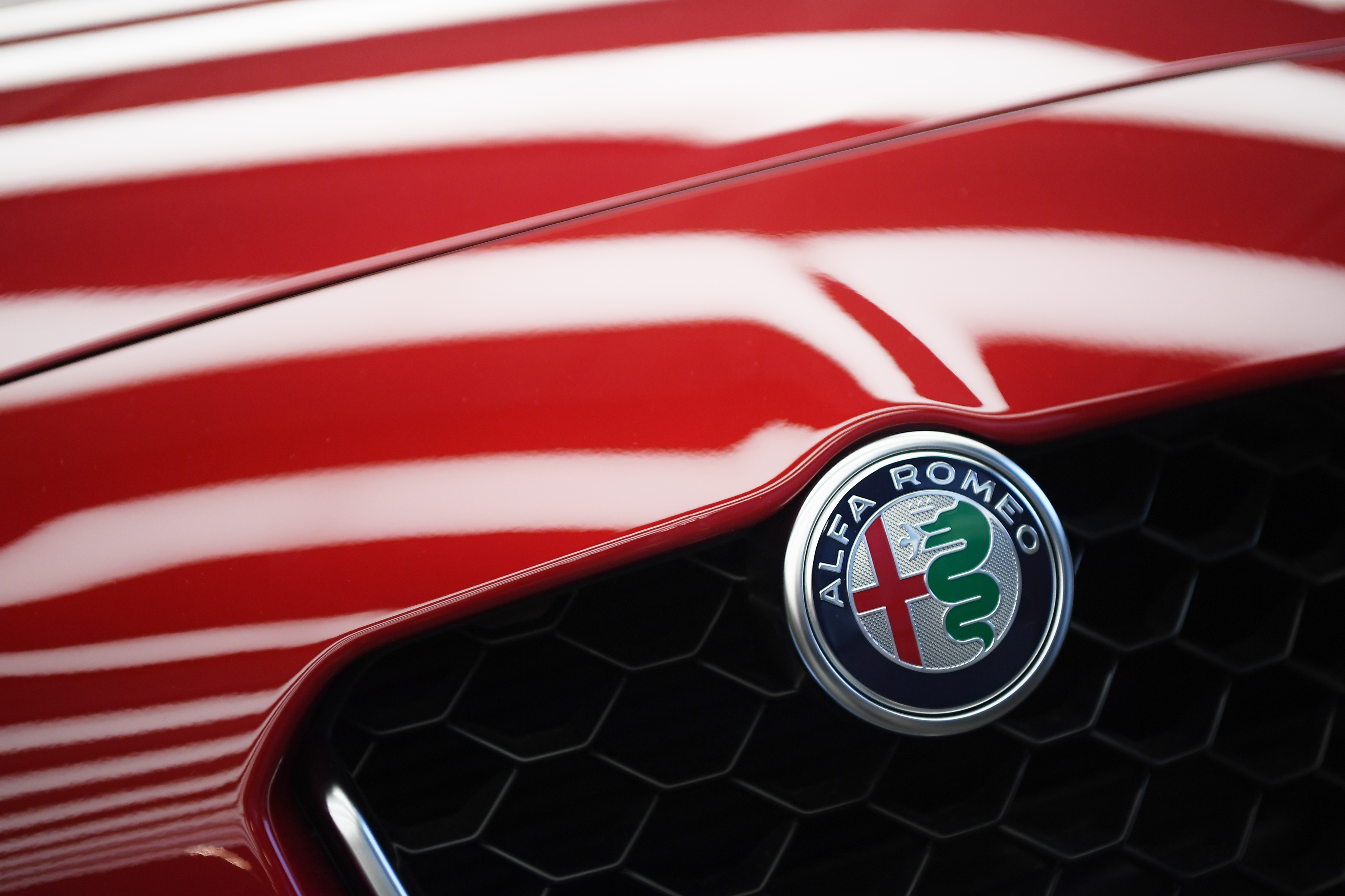 The Alfa Romeo logo on a red car.