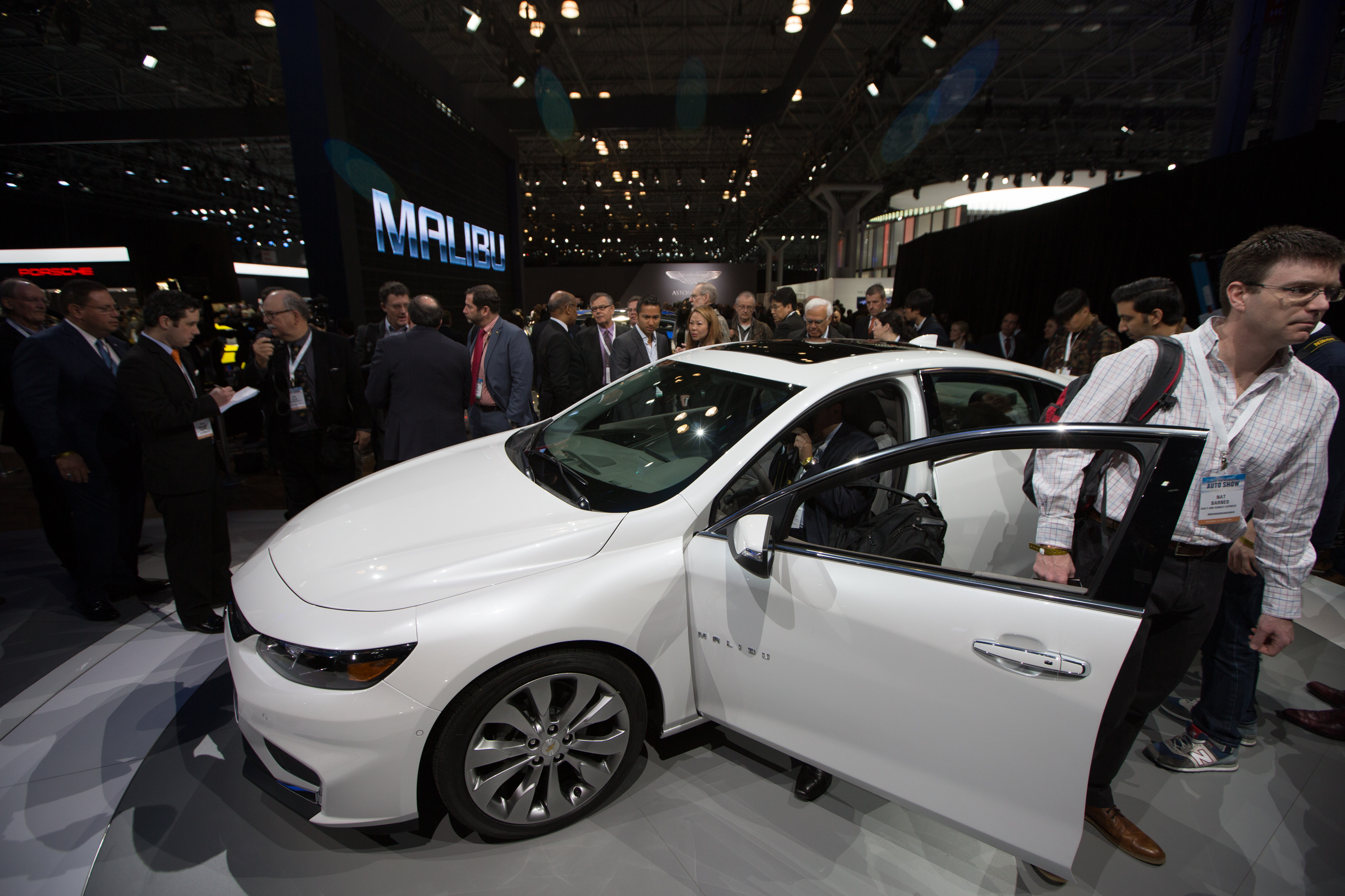 People checking out a Chevy Malibu at an auto show