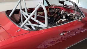 Red 1970s Fiat Spider with a white 4-point roll bar installed
