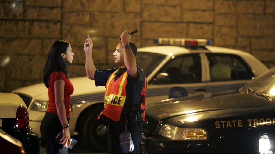 A police officer preforms a DUI test on a woman