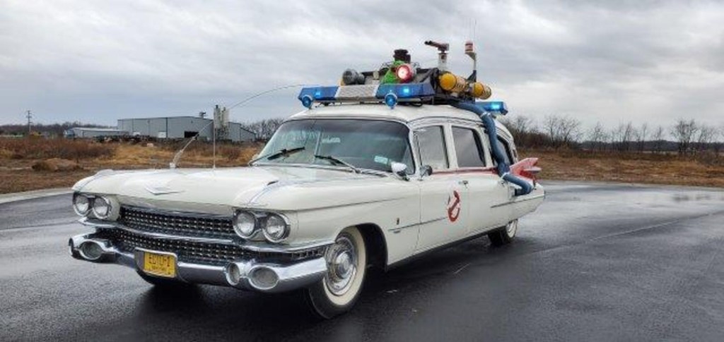The Ecto-1 Cadillac movie car sitting in a wet parking lot. 