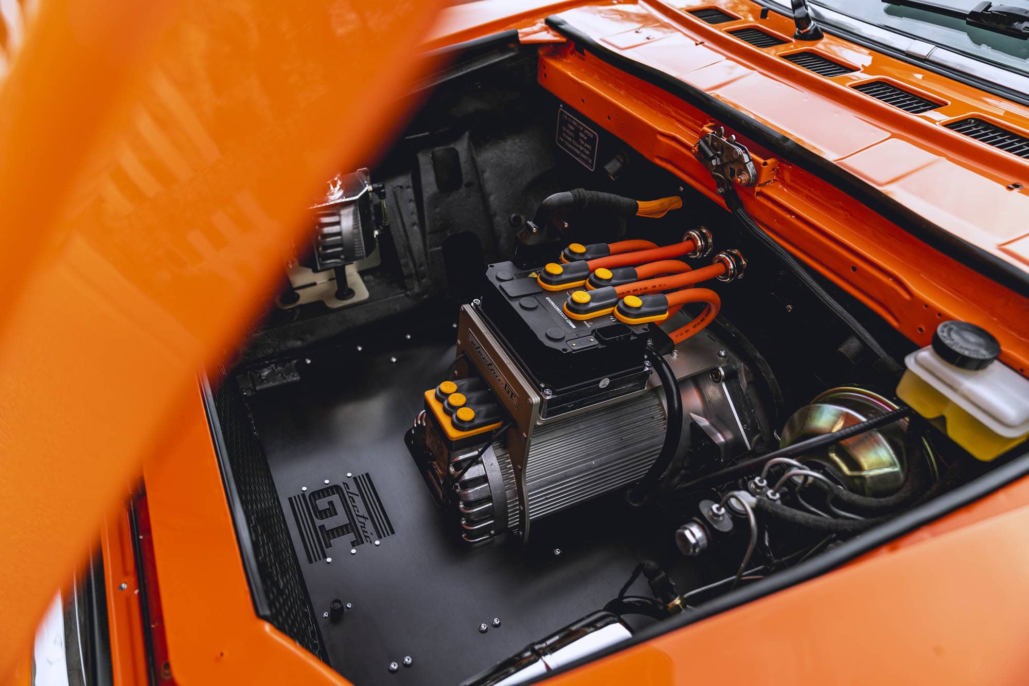 The hood is raised on a 1982 Fiat Spider to expose the electric crate motor swap.