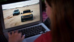 A woman checking out the new 2021 Ford Bronco on her laptop