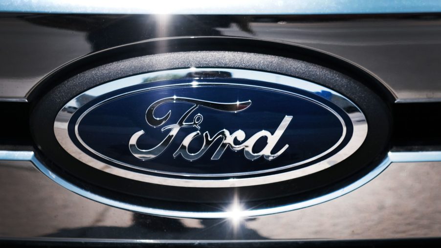 The blue Ford logo on a chrome grill of a car.