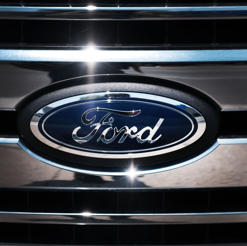 The blue Ford logo on a chrome grill of a car.