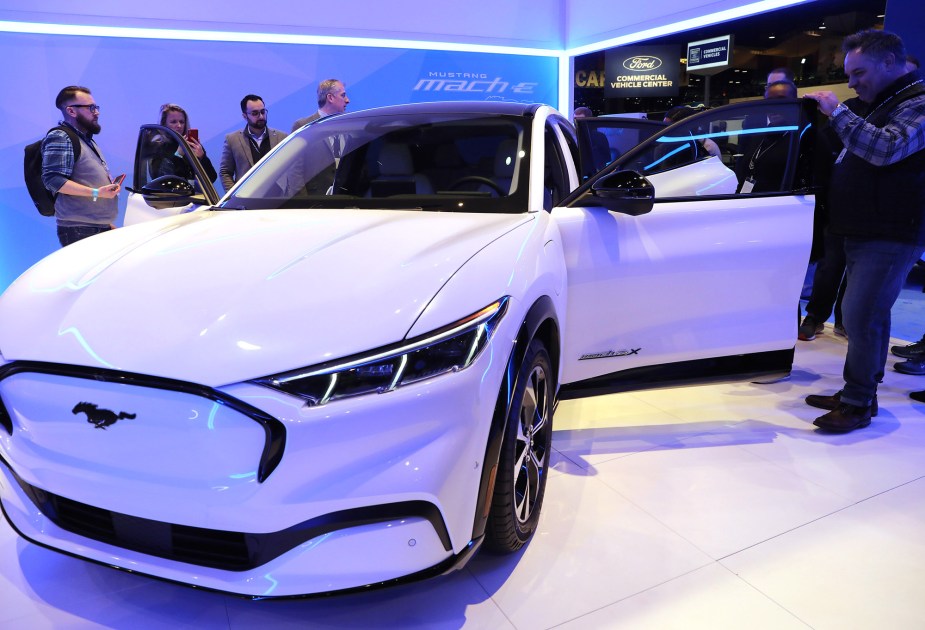 Attendees examine the Ford Mustang Mach-E all electric vehicle at the Chicago Auto Show