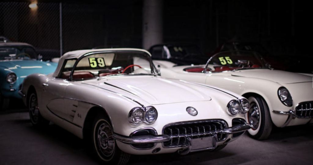 Two white classic Chevrolet Corvette model in a warehouse