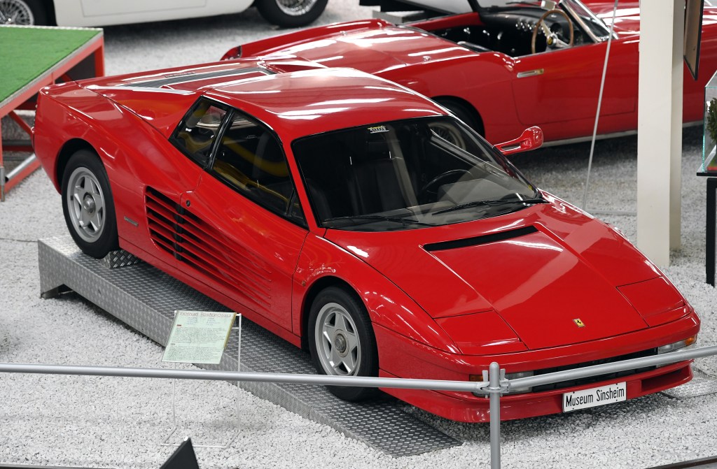 A red Ferrari Testarossa on display in a museum.