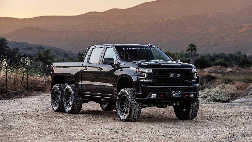A black Hennessey Goliath 6x6 parked in a valley road.