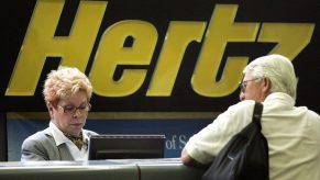 A customer is at the Hertz counter discussing a rental with an employee