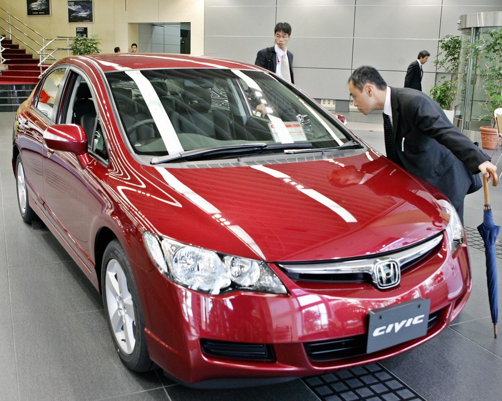 A car shopper inspecting a Honda Civic