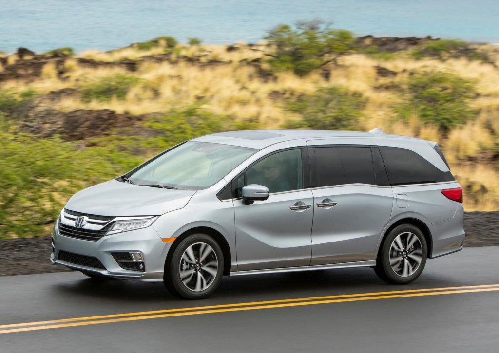 silver Honda Odyssey at speed on a scenic road