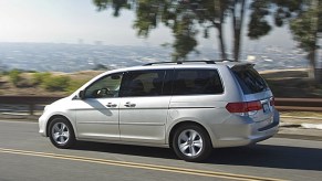 2008 silver Honda Odyssey driving on a scenic road