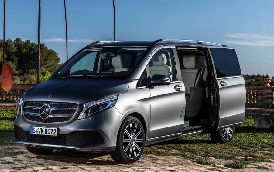 silver mercedes minivan with the sliding side door open to reveal a luxurious interior 