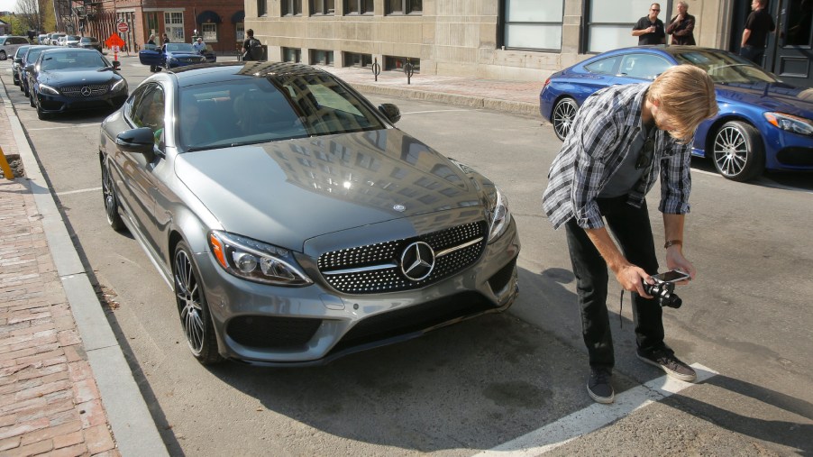 Greg Carloss [cq] of Baltimore shoots video of a Mercedes C300 coupe on Market Street