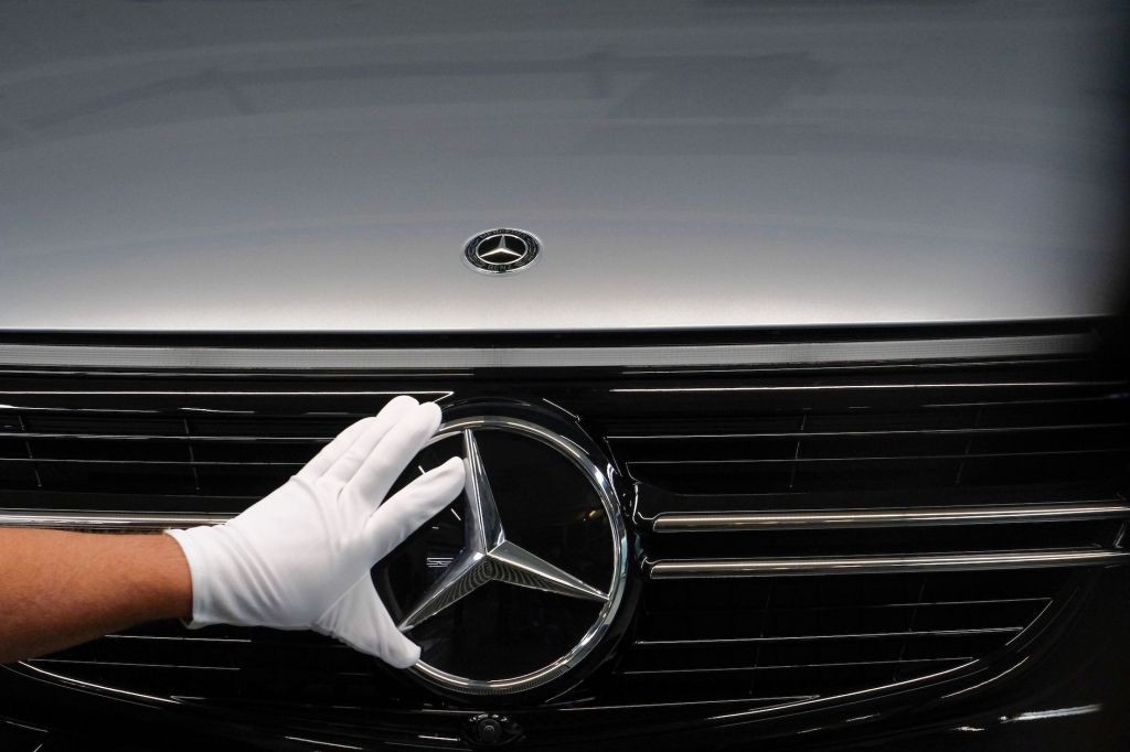 An employee adjusts a Mercedes-Benz three-pointed star emblem at an assembly line for GLC sports utility vehicle