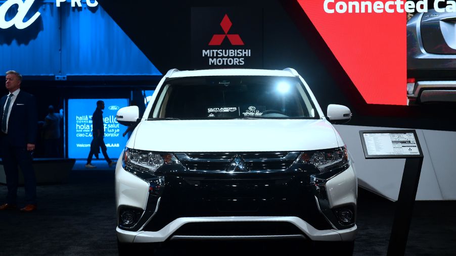 A white Mitsubishi Outlander on display at an auto show