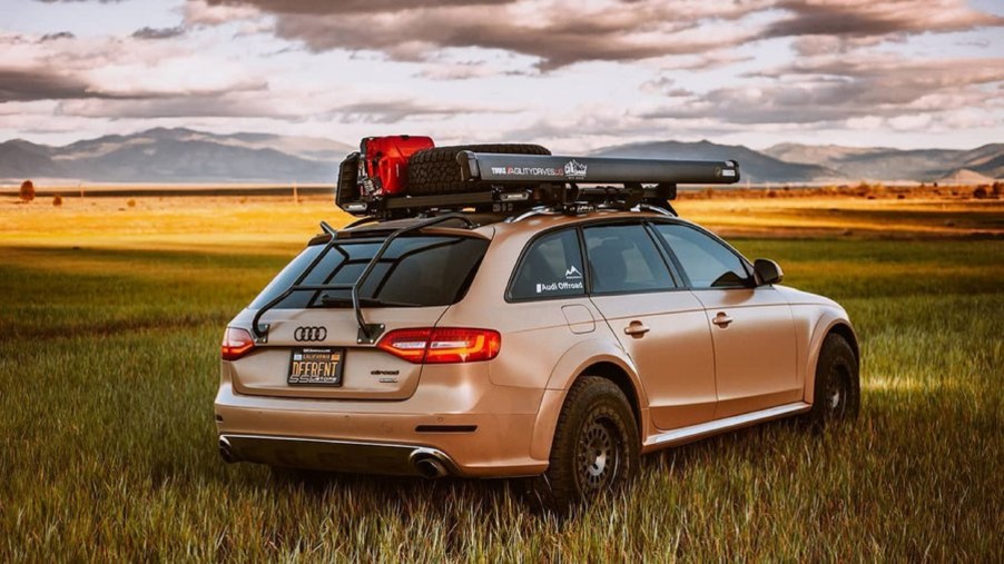 Rear view of a tan modified 2015 Audi A4 Allroad in an open sunset field