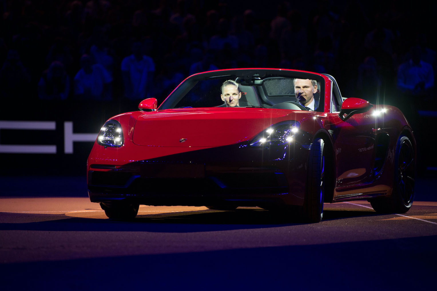 Karolina Pliskova from the Czech Republic (L) driving a Porsche 718 Boxster GTS with the CEO¬†of Porsche AG, Oliver Blume, in the Centre Court during the award ceremony after her victory against Vandeweghe from the US