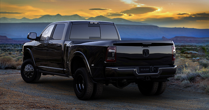 a black on black pickup truck by Ram trucks with a mountainous sunset backdrop 