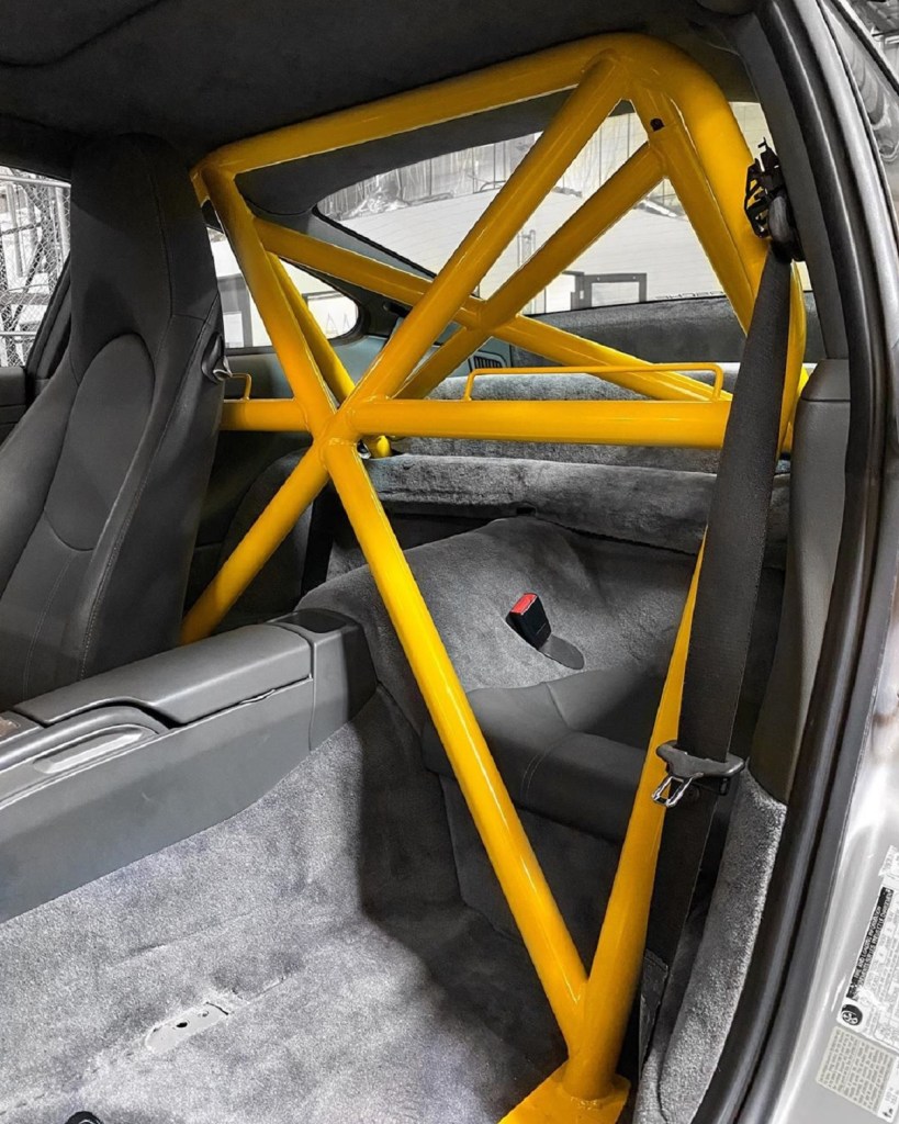 A yellow 4-point roll cage installed in a Porsche 911