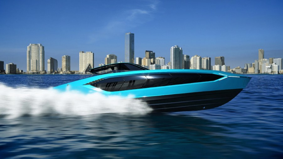 Blue Tecnomar by Lamborghini 63 yacht cutting through the water in front of a city