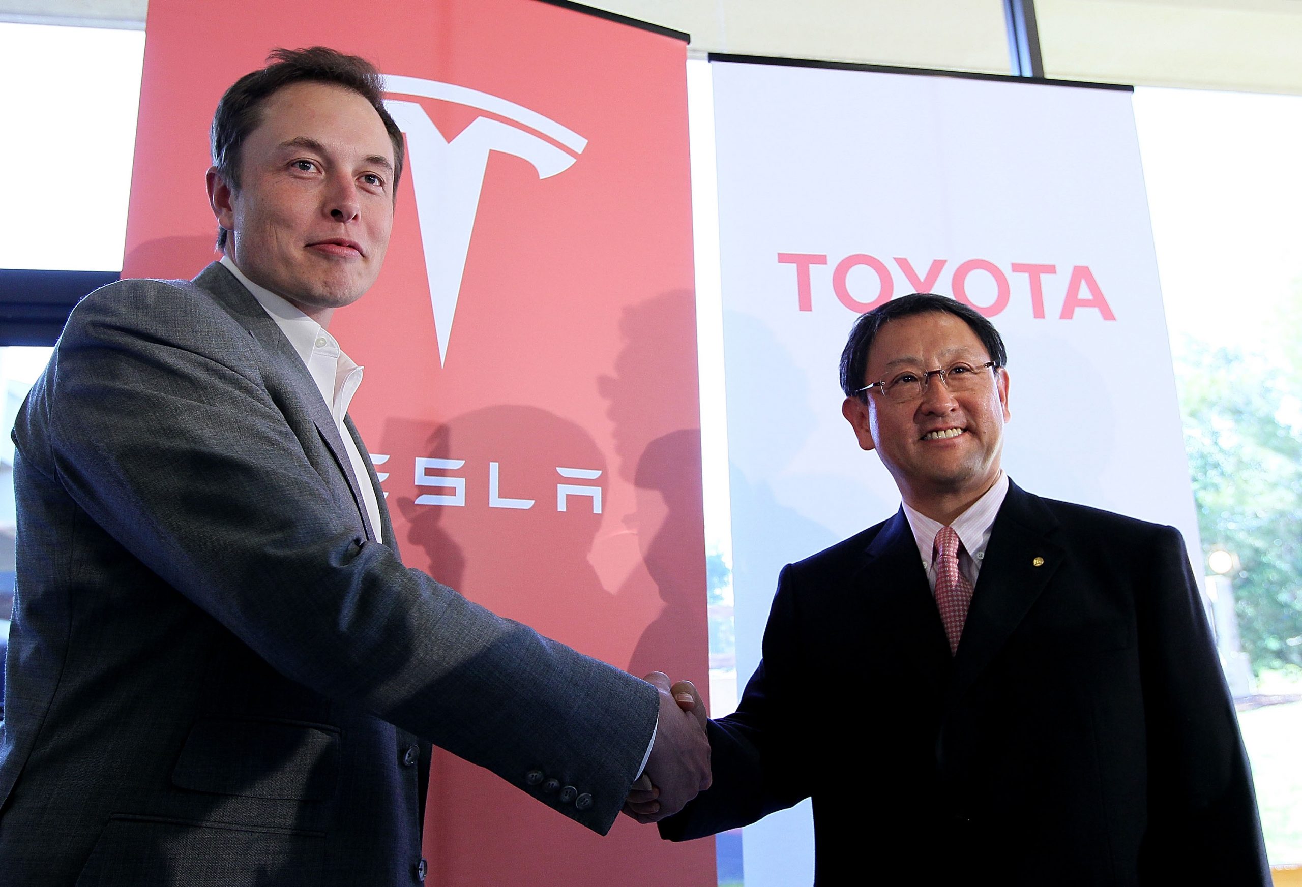 The CEOs of Tesla and Toyota shaking hands